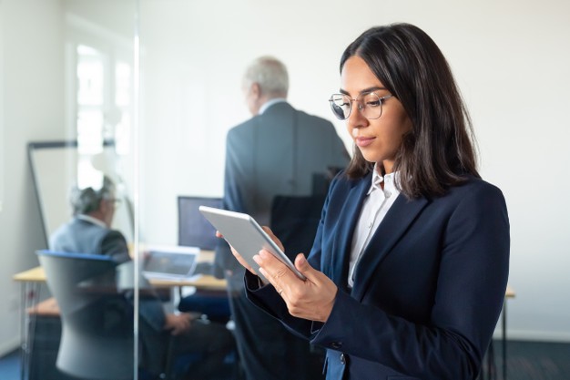 dame dans un bureau qui consulte une tablette éléctronique